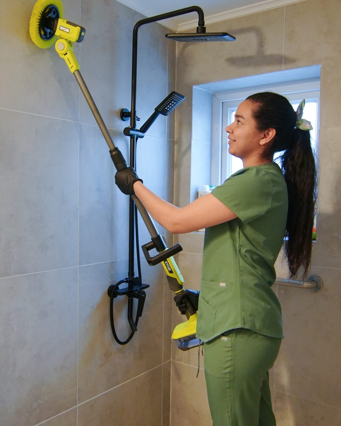 Profesional KLÁZA limpiando la ducha con cepillo eléctrico